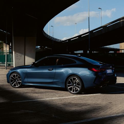 Three quarter rear view model BMW M440i xDrive Coupé G22 2020 BMW M440i xDrive Coupé Arctic Race Blue metallic G22 2020 three quarter rear view with model
