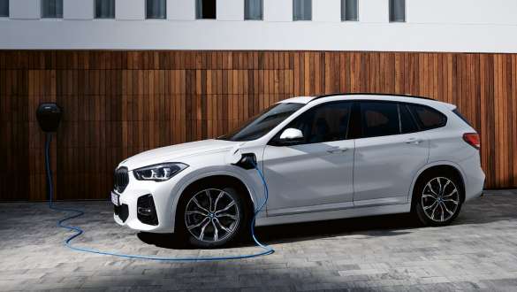 Plug-in хибрид BMW X1 xDrive25e F48 LCI тричетвртински страничен поглед Plug-in хибрид BMW X1 xDrive25e F48 LCI тричетвртински страничен поглед при полнење