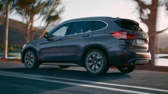 BMW X1 F48 тричетвртински поглед одзади BMW X1 F48 LCI тричетвртински поглед одзади во возење пред планина