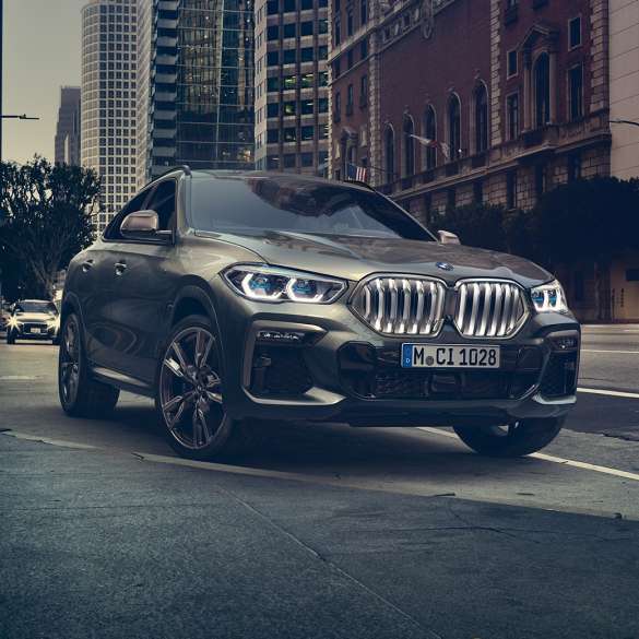 BMW X6 Professional адаптивна М суспензија BMW X6 од тричетвртинска перспектива однапред пред урбана заднина.