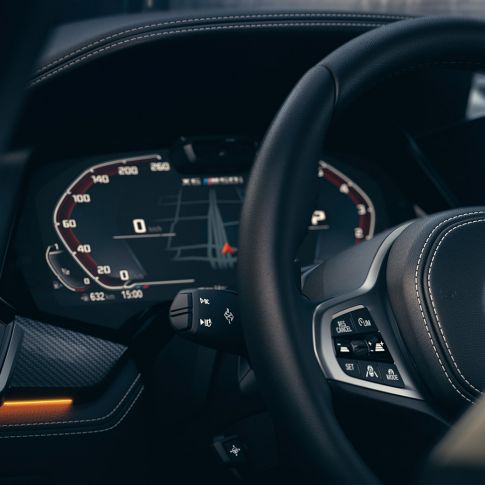 BMW системи за помош на возачот. Поглед одблизу на внатрешноста на BMW со фокус на инструмент кластерот.