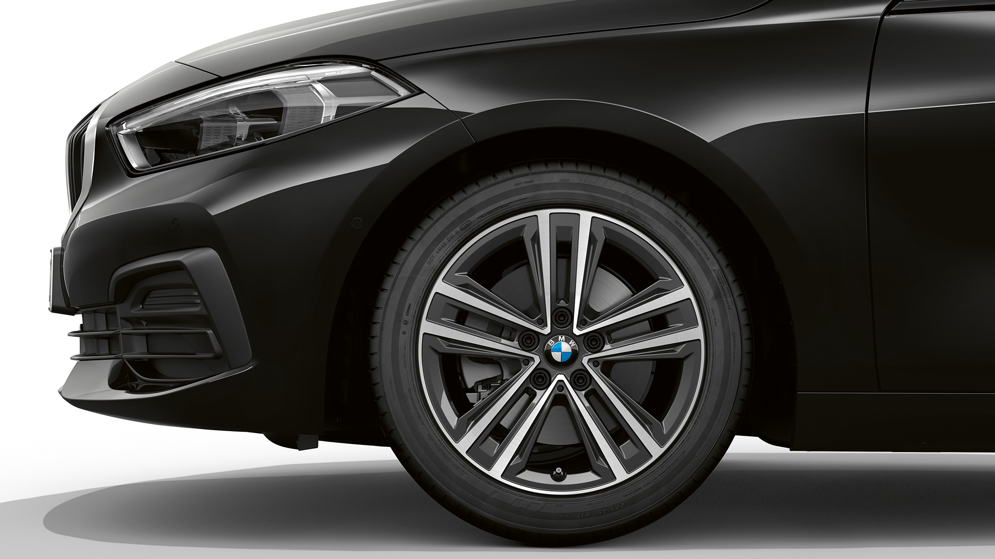 Леснометални бандажи од 16 инча со краци во облик на ѕвезда од тип 517. BMW Серија 1 модел Advantage во црна боја, страничен приказ на предница со леснометални бандажи од 16 инча со краци во облик на ѕвезда од тип 517.