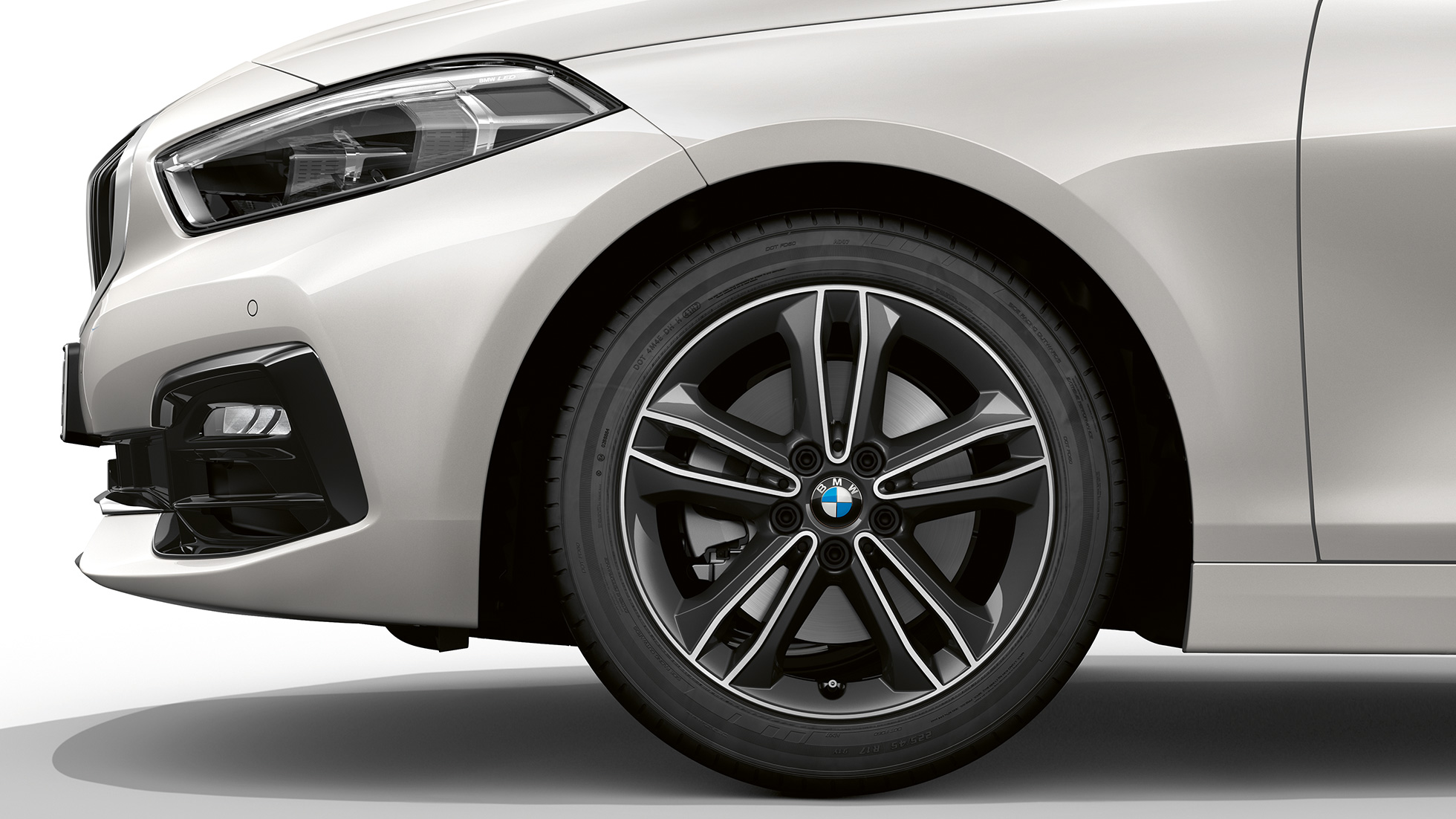 Леснометални бандажи од 17 инча со двојни краци од тип 549. BMW Серија 1, модел Sport Line во Mineral White бела металик боја, страничен приказ на предница со леснометални бандажи од 17 инча со двојни краци од тип 549.