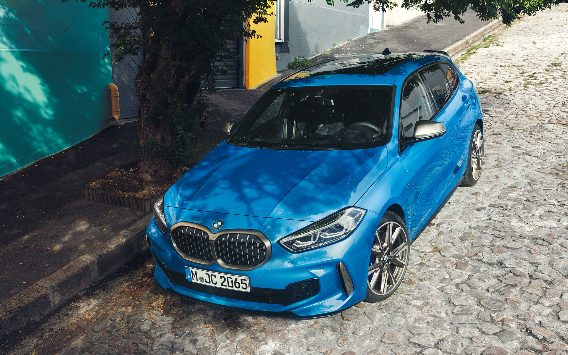 BMW серија 1 M135i F40 во Misano Blue металик, тричетвртински поглед однапред, паркиран крај патот од пртичја перспектива