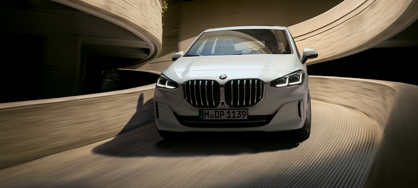 BMW Серија 2 Active Tourer U06 2021 Mineral White бела металик боја во возење на паркиралиште поглед однапред
