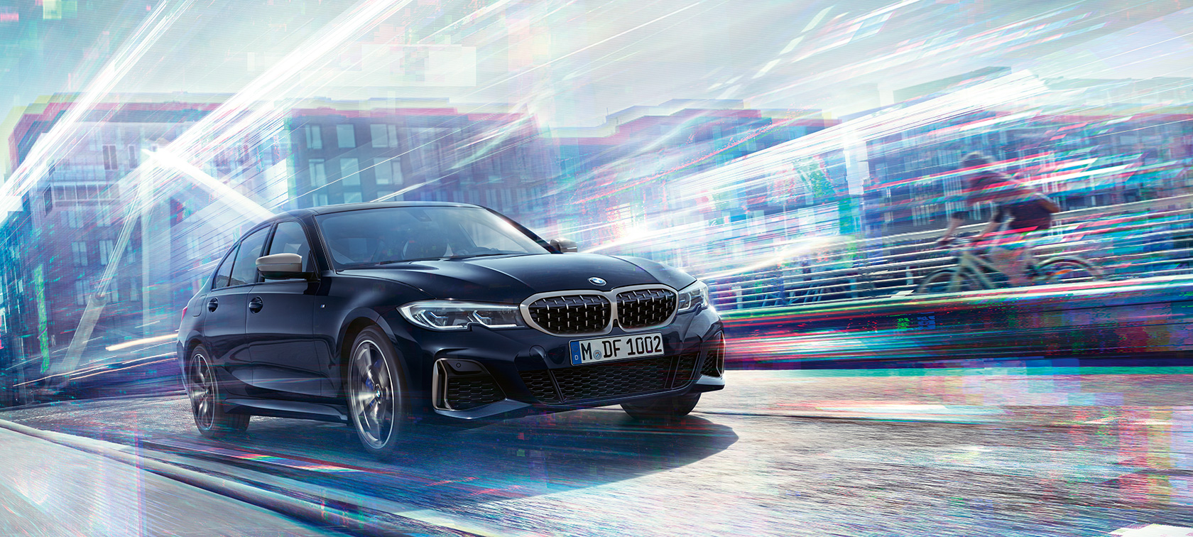 BMW Серија 3 Седан, BMW M340i xDrive. Тричетвртински страничен поглед на BMW M340i xDrive во возење наспроти урбана заднина.