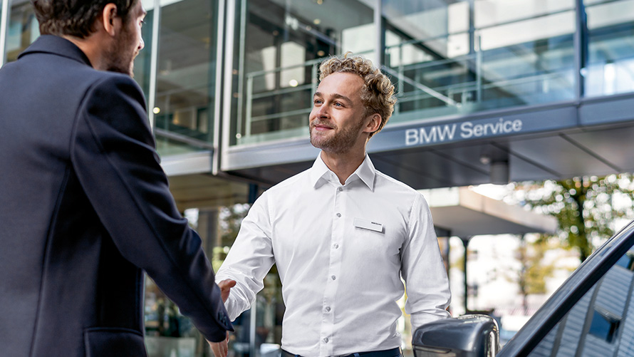 Вработен во BMW Услуги го поздравува купувачот Вработен во BMW Услуги го поздравува купувачот
