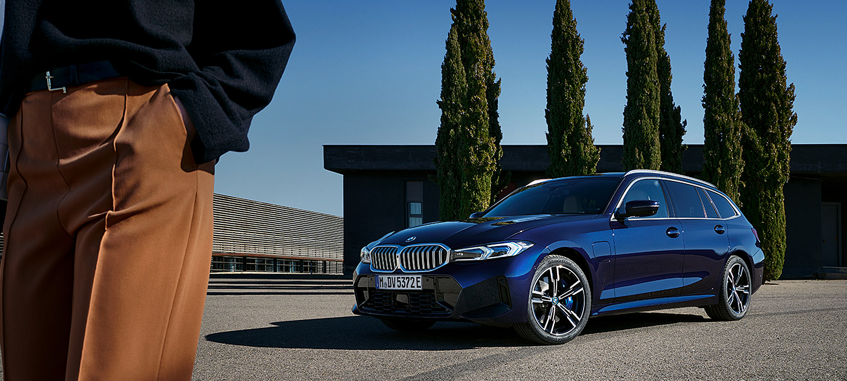 BMW Серија 3 Touring LCI G21 Tansanit Blue II сина боја тричетвртински преден поглед стои пред дрвја