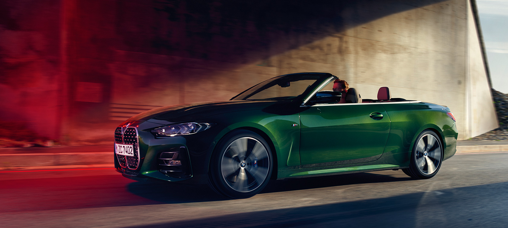 Тричетвртински страничен кадар на BMW Серија 4 Кабриолет G23 2020 во движење BMW Серија 4 Кабриолет G23 2020 Sanremo зелена металик боја тричетвртински страничен кадар во движење