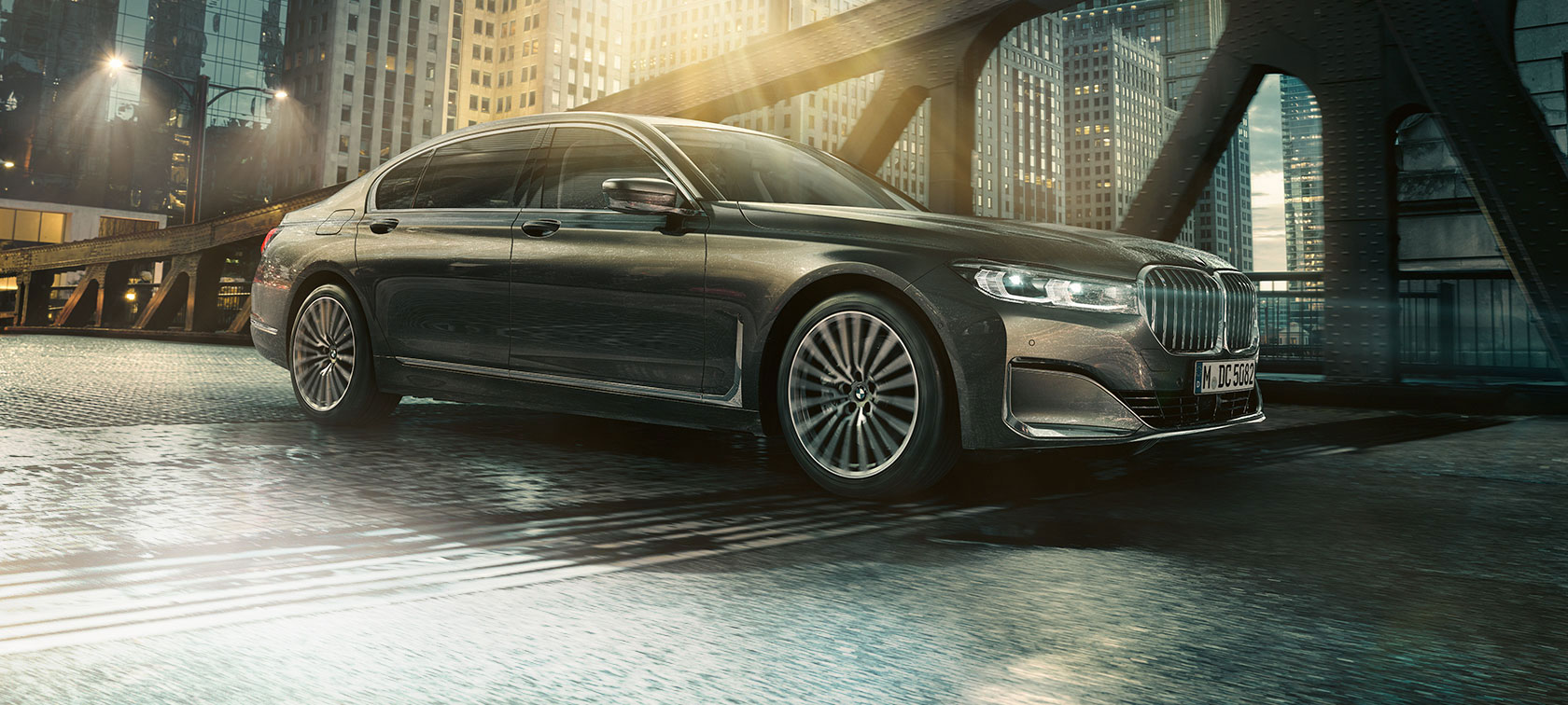 BMW Серија 7 Седан страничен поглед BMW Серија 7 Седан страничен поглед со отворена врата пред осветлен хотел