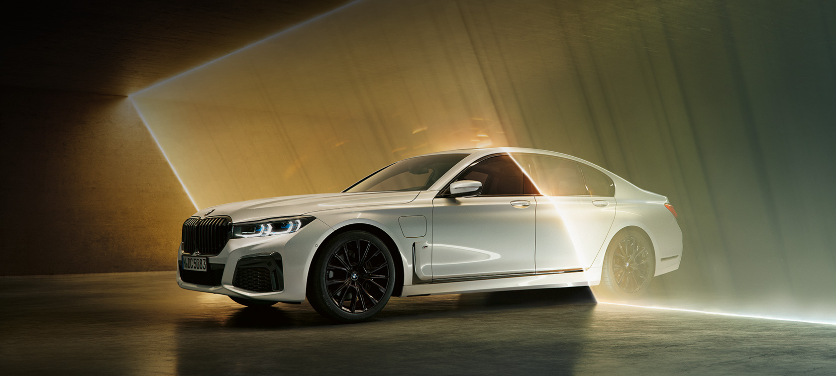 BMW Серија 7 Седан, бел, тричетвртински преден кадар BMW Серија 7 Седан: бел BMW во тричетвртински преден кадар опкружен со светлина
