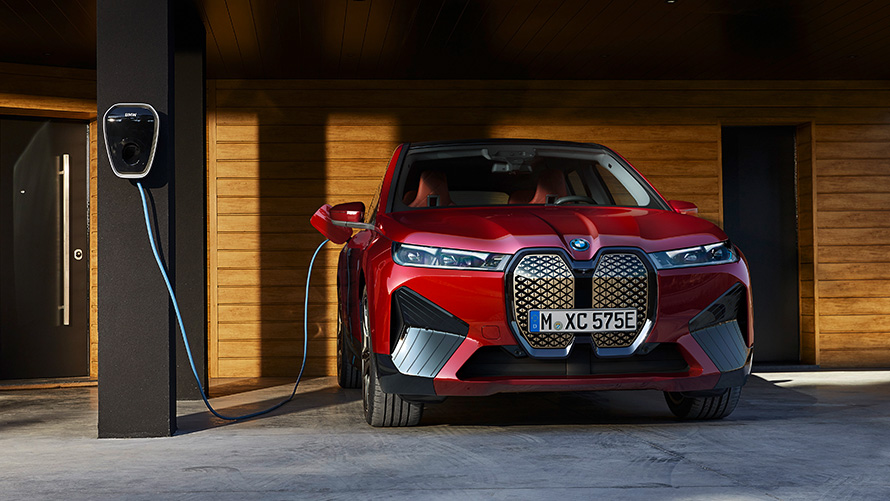 BMW iX i20 electric SUV BMW iX xDrive50 charging BMW iX i20 2021 electric SUV BMW iX xDrive50 Aventurin Red charging with a BMW Wallbox charging