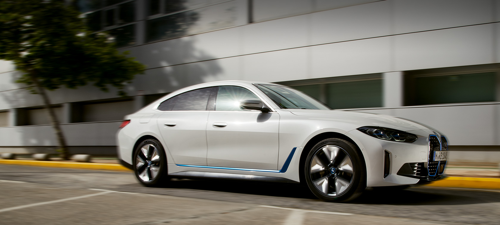BMW i4 eDrive40 G26 2021 тричетвртински страничен поглед во возење пред зграда BMW i4 eDrive40 G26 2021 тричетвртински страничен поглед во возење пред зграда