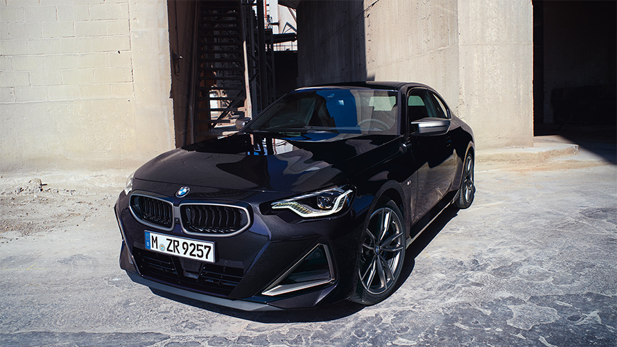 BMW M240i xDrive Coupé G42 2021 Black Sapphire металик тричетвртински поглед однапред паркиран пред магацин