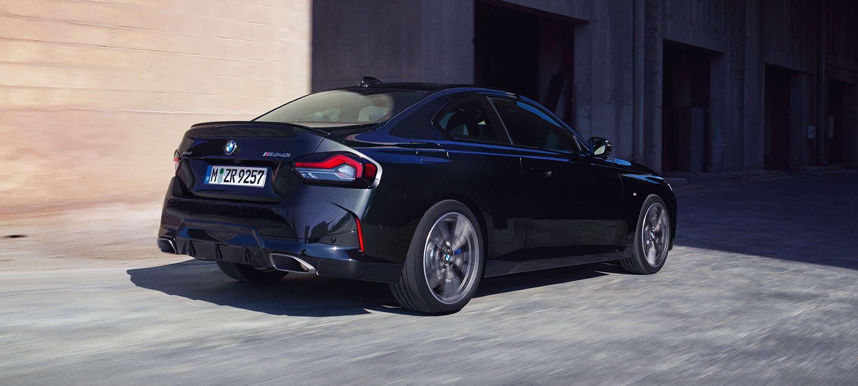 Тричетвртински поглед одзади на BMW M240i xDrive Coupé G42 2021 BMW M240i xDrive Coupé G42 2021 Black Sapphire металик тричетвртински поглед одзади во возење