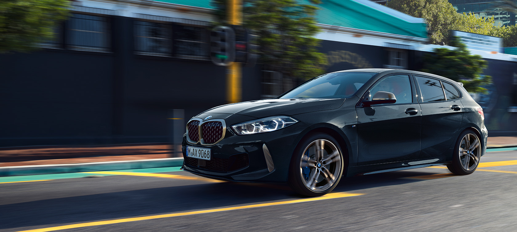 Потполно новиот BMW M135i xDrive во Black Sapphire црна металик боја, тричетвртински страничен приказ во возење.