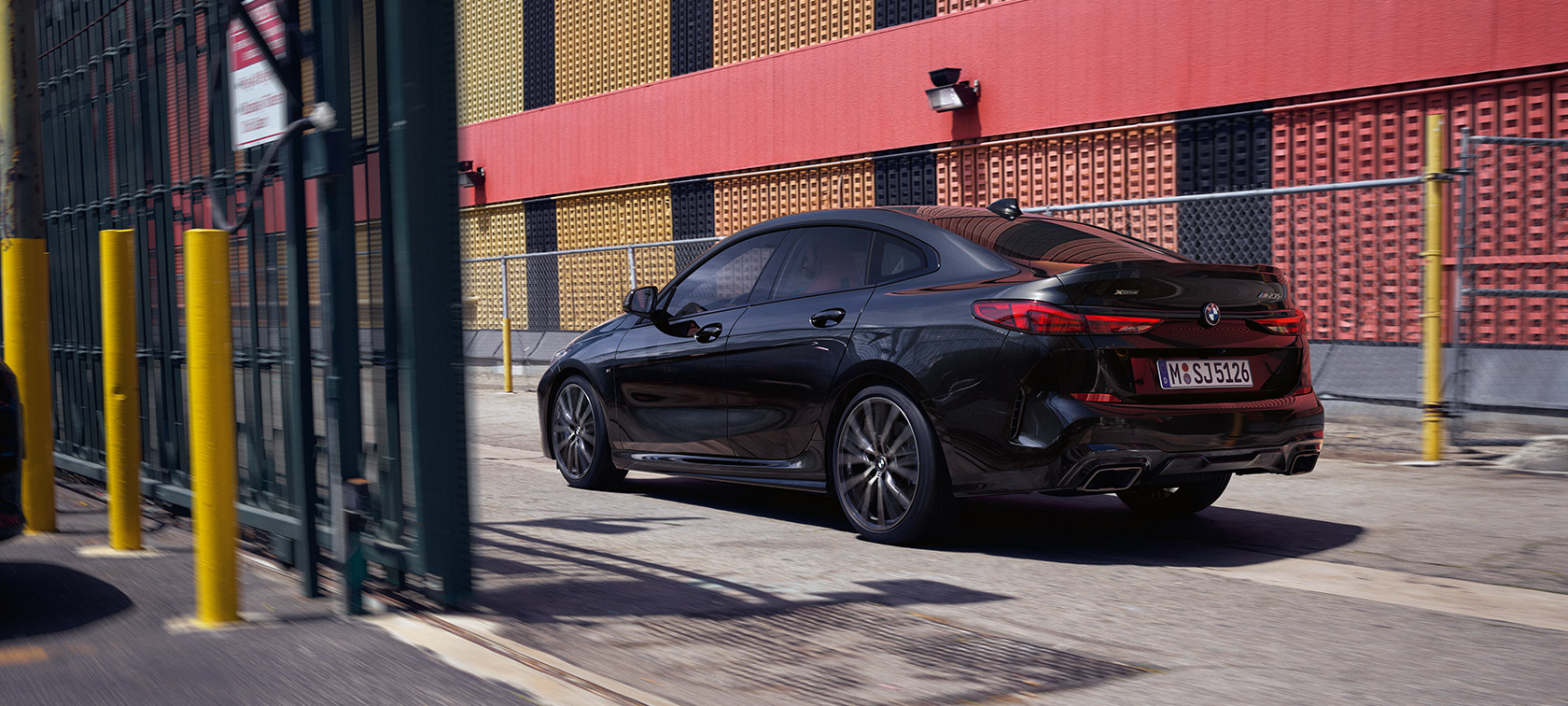 BMW M235i xDrive Gran Coupé F44 тричетвртински поглед одзади во возење BMW M235i xDrive Gran Coupé F44 Black Sapphire metallic тричетвртински поглед одзади во возење