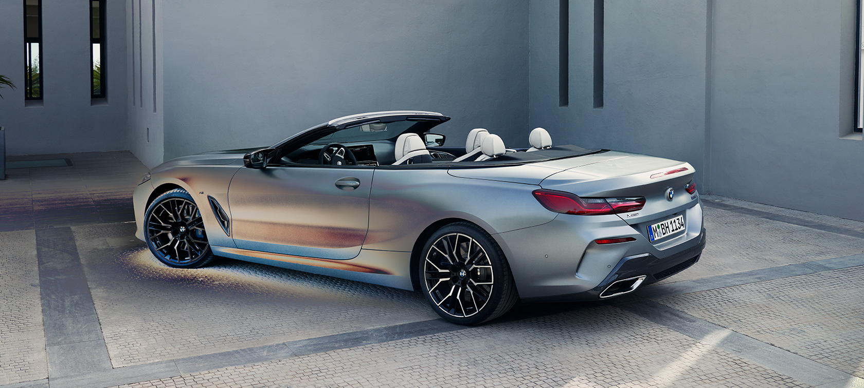 Тричетвртински поглед одназад на BMW M850i xDrive кабриолет G14 LCI Facelift 2022 BMW M850i xDrive кабриолет G14 LCI Facelift 2022 BMW Individual мразно чиста сива металик боја, тричетвртински поглед одназад, на паркинг