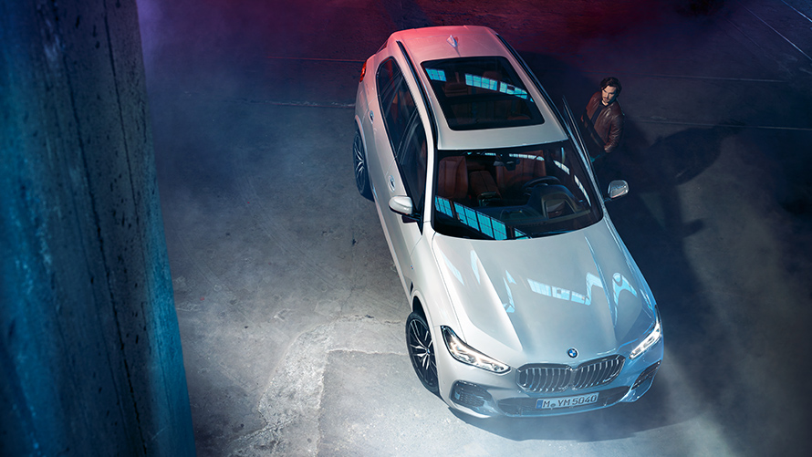 Ноќен кадар на BMW X5 од горната страна во урбана средина