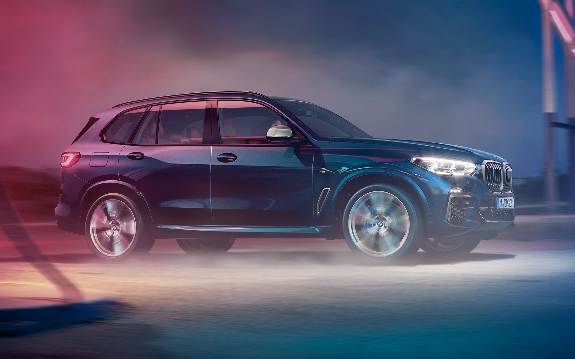 BMW X5 M50d во движење Кадар на возење на BMW X5 M50d ноќе во урбана средина