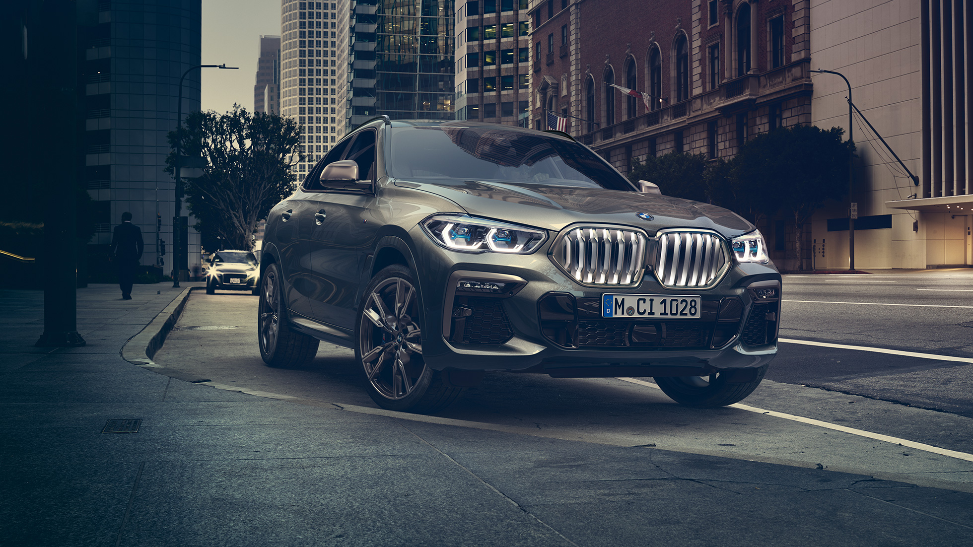 BMW X6 Professional адаптивна М суспензија BMW X6 од тричетвртинска перспектива однапред пред урбана заднина.