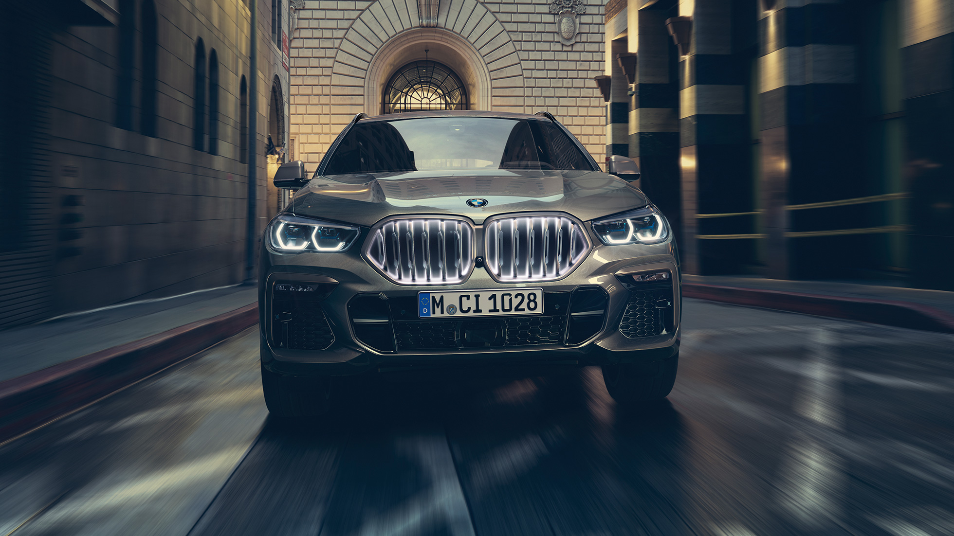 BMW X6 со BMW ‘Iconic Glow’ бубрежна решетка. BMW X6 поглед однапред пред урбана заднина.