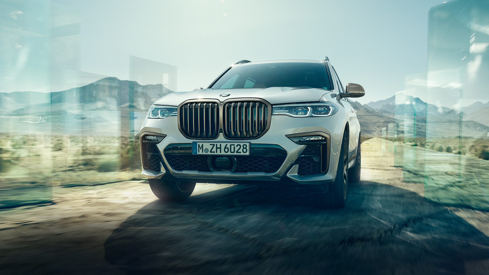 BMW X7 M50d, кадар од низок агол BMW X7 M50d: кос кадар од низок агол на бел BMW X7 додека вози