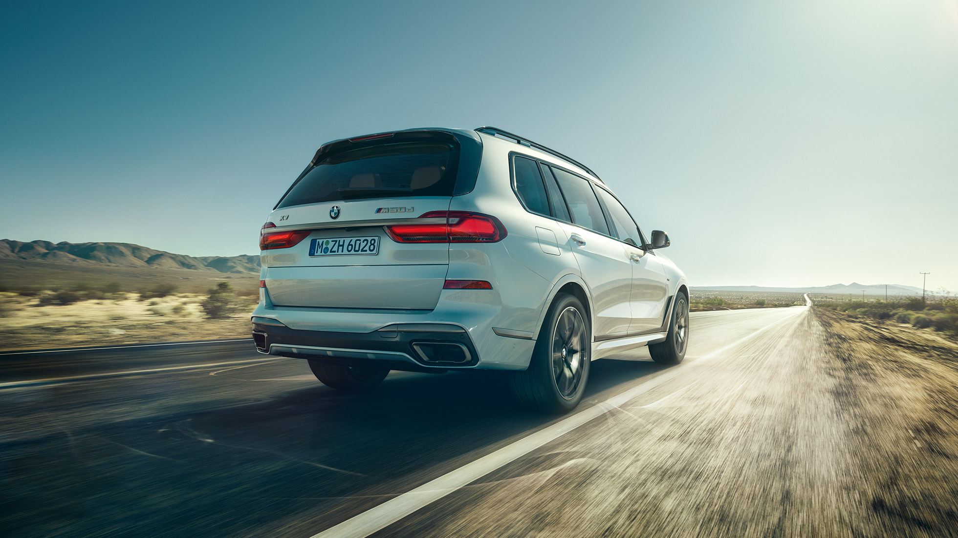 BMW X7 M50d, заден кадар BMW X7 M50d: заден кадар на бел BMW X7 додека вози