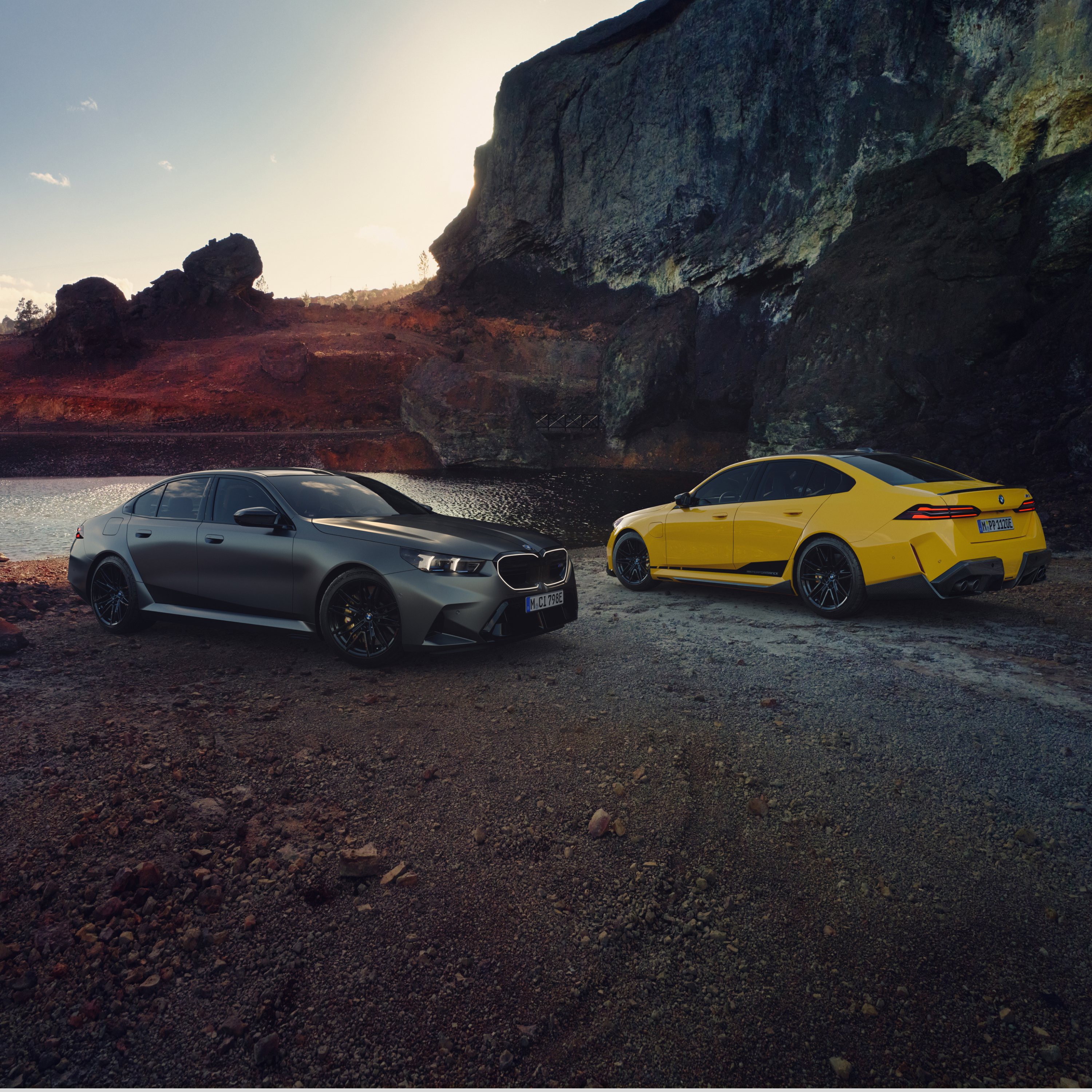 Два автомобили BMW Серија 5 се паркирани на плажа пред карпи